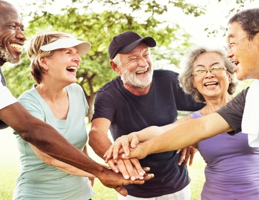 Group of adults puts their hands together